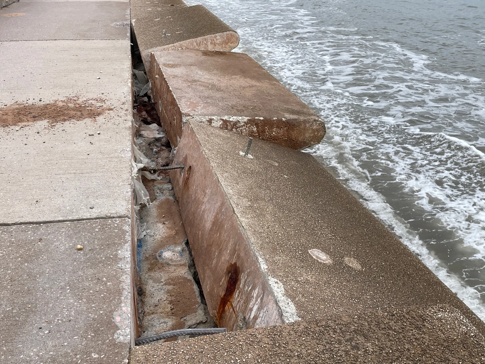 Destruction and damage of sea wall defensive structure and wave deflection units on coastal promenade at Dawlish in Devon after violent storms